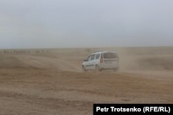 Сайхин ауылы жанынан дала жолымен өтіп бара жатқан автокөлік. Батыс Қазақстан облысы, 30 маусым, 2023 жыл.