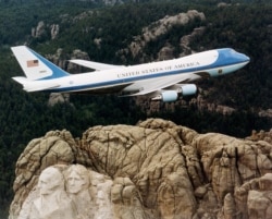 Boeing 747 ұшағы (Air Force One деген атпен танымал) АҚШ-тың Оңтүстік Дакота штатындағы Рашмор тауының үстінен ұшып барады. Әлемде мұндай екі-ақ ұшақ бар. 2001 жыл.